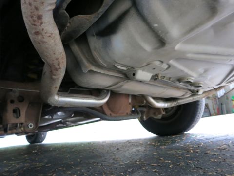 1991 Ford LTD Crown Victoria - Undercarriage view showing the fuel tank, dual exhaust routing and rear suspension components of a vehicle.