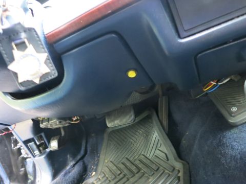 1991 Ford LTD Crown Victoria - California Highway Patrol star badge is clipped to the steering column over the blue footwell, pedals and rubber floor mat.