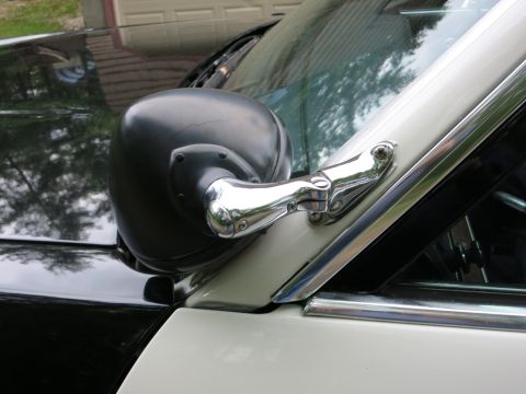 1991 Ford LTD Crown Victoria - Close-up of a black door-mounted spotlight on chrome arm at the A-pillar of a black-and-white police car.