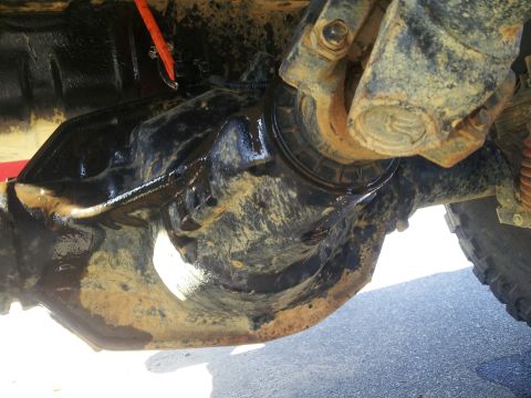 1988 Ford Bronco - Close-up view of a vehicle's rear axle differential and driveshaft, showing some wear and tear.
