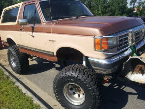1988 Ford Bronco - This lifted Ford Bronco has a two-tone paint scheme and aggressive off-road tires.