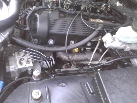 2003 Ford Crown Victoria - Engine bay components including the engine block, brake fluid reservoir, and ABS module are visible.