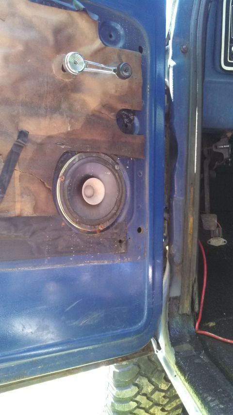 1979 Ford Bronco - Close-up view of the inside of a vehicle door, showing the speaker and window crank mechanism.