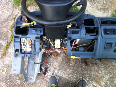 1992 Ford Bronco - Dashboard and steering column removed from vehicle, showing internal wiring and fuse box.
