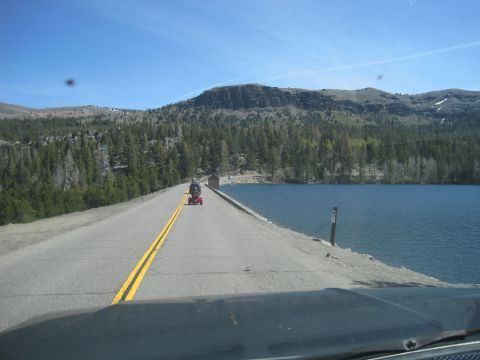 1989 Ford Bronco - A person on a mobility scooter travels down a road next to a large body of water.