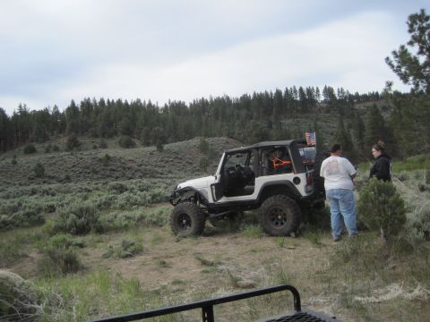 1989 Ford Bronco - Two people stand next to a white Jeep Wrangler in a natural, outdoor setting.