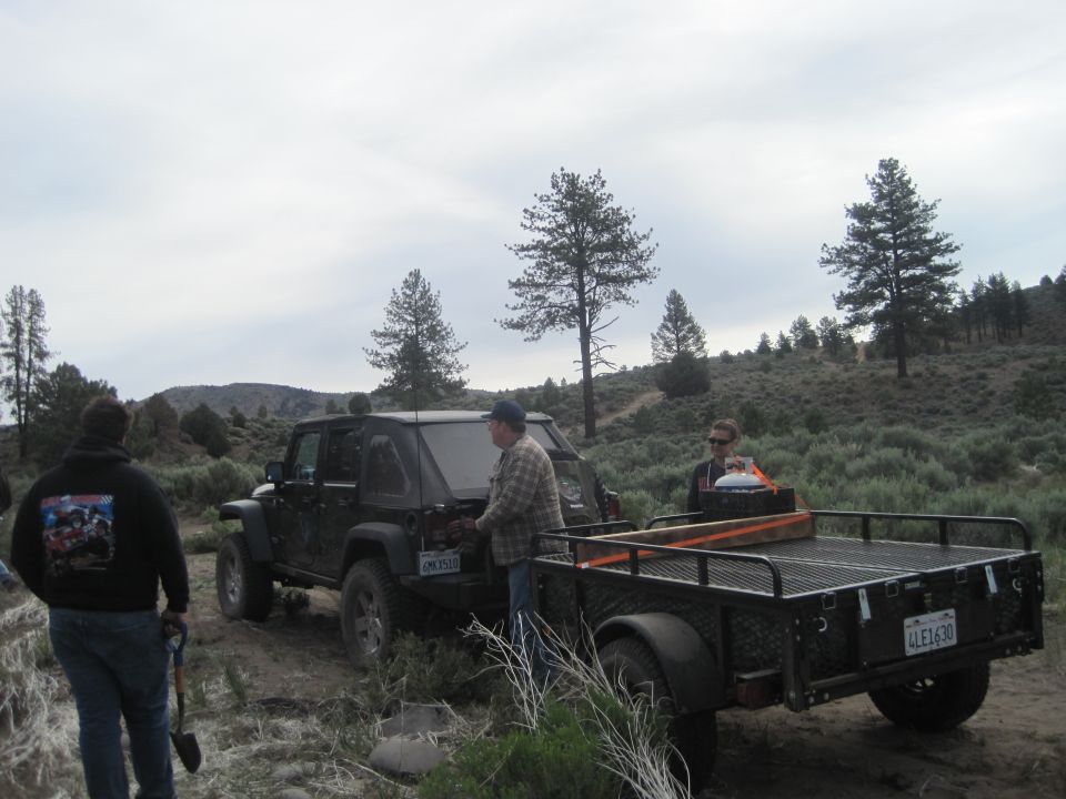 Black Jeep Wrangler towing a trailer, rear view