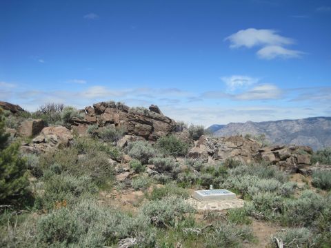 1989 Ford Bronco - A marker sits on a rocky hillside covered in sagebrush, with mountains in the distance.
