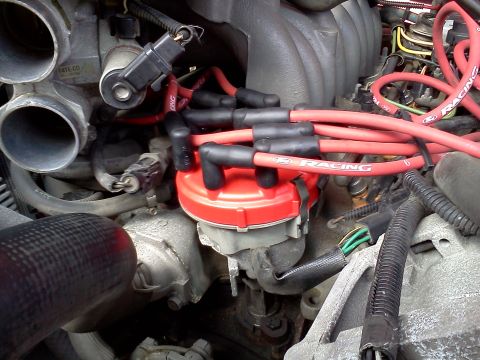 1995 Ford Bronco - Close-up of an engine's distributor cap and spark plug wires.