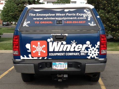1975 Ford Ranchero - A blue pickup truck with a white camper shell displays advertising for Winter Equipment Company, Inc.