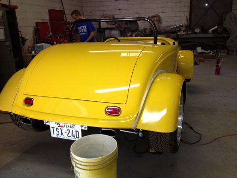 1975 Ford Ranchero - Yellow hot rod roadster in a garage, rear view. Texas license plate TSX-240 is visible.