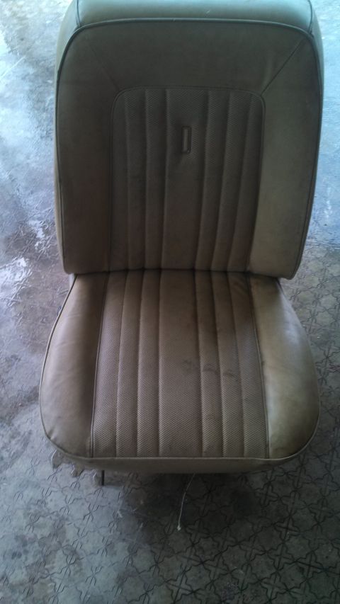 1979 Ford Bronco - A tan vinyl seat with a distinctive stitching pattern and a small emblem on the backrest is shown.