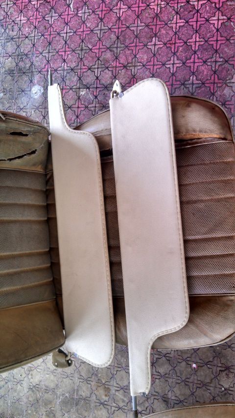 1979 Ford Bronco - Close-up of two sun visors and a damaged seat cushion, likely interior parts from an older vehicle.