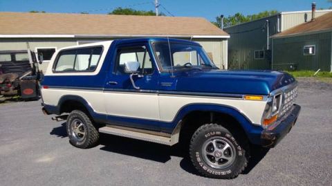 1979 Ford Bronco - This two-tone Ford Bronco is seen from a three-quarter front angle, parked in front of a commercial building.