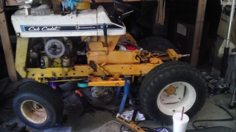 Cub Cadet tractor with hydrostatic transmission, white and yellow body, on stands