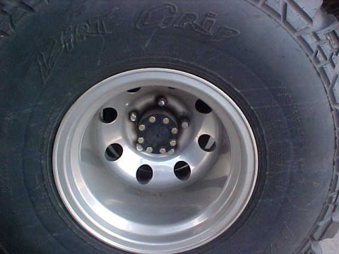 1992 Ford Bronco - A close-up view of a vehicle's tire and wheel assembly, showing the tread pattern and rim details.