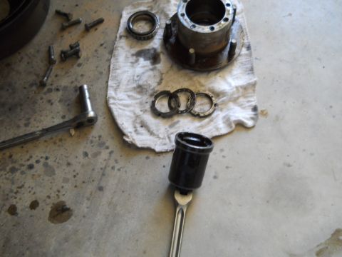 1992 Ford Bronco - Disassembled wheel hub components and tools are spread out on a garage floor.