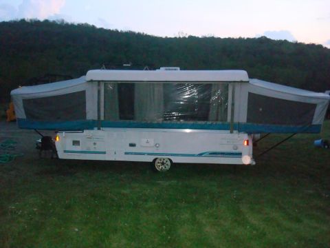 2007 Mazda 6 - Pop-up camper trailer with sides extended, parked on grass at dusk.