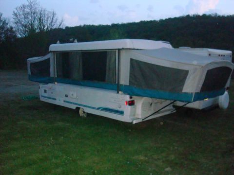 2007 Mazda 6 - This pop-up camper is set up in a grassy area with trees in the background.