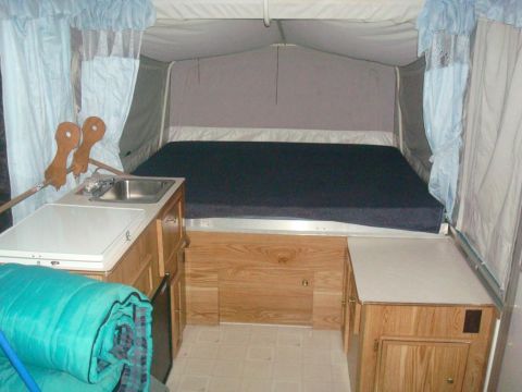 2007 Mazda 6 - Interior of a pop-up camper with a bed, sink, and counter space visible.