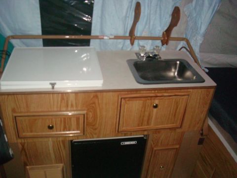2007 Mazda 6 - Interior view of a camper's kitchenette area, a sink, stovetop, and storage cabinets.