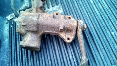 1979 Ford Bronco - A rusty steering gear box, likely a replacement part, is shown against a blue ribbed background.