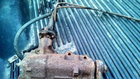 1979 Ford Bronco - This is a rusty steering gear box with hoses, likely a salvaged part.