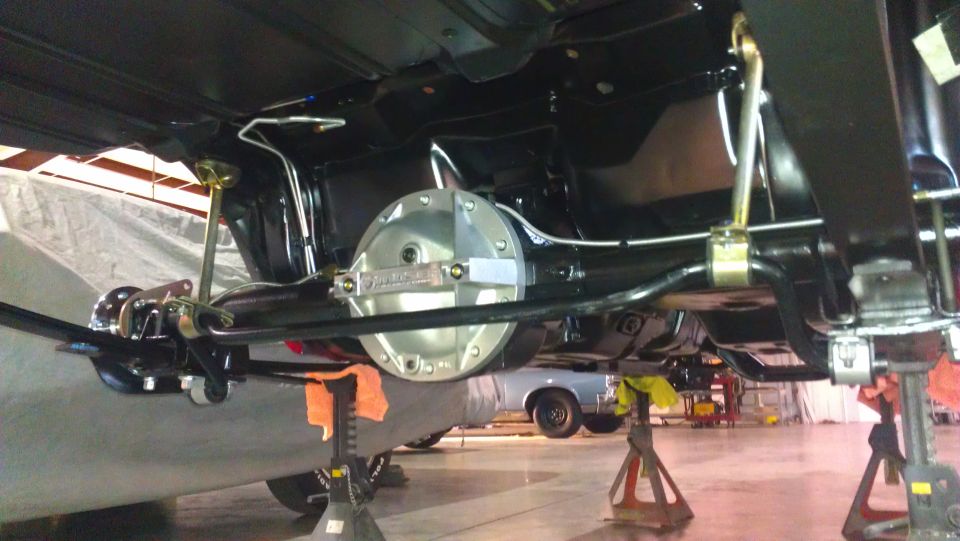 Underside view of a car's rear axle assembly with a polished differential cover
