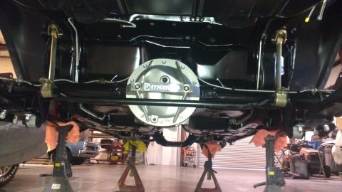 1972 Pontiac Trans Am - The underside of a vehicle is supported by jack stands, revealing its drivetrain and suspension parts.