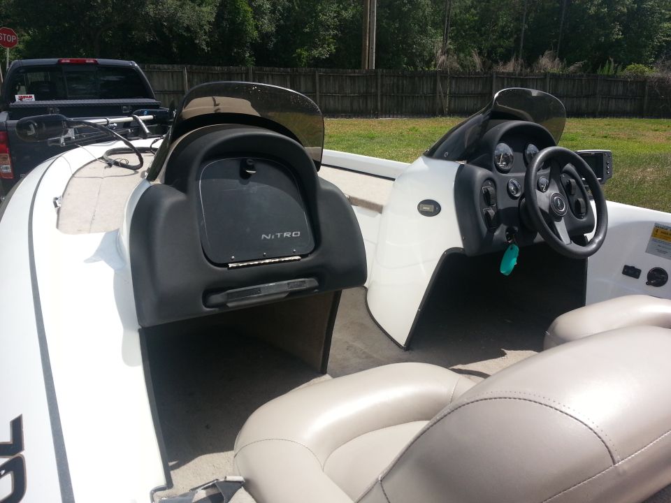 White boat interior with beige seats, black dashboard, and steering wheel. A Nitro logo is visible
