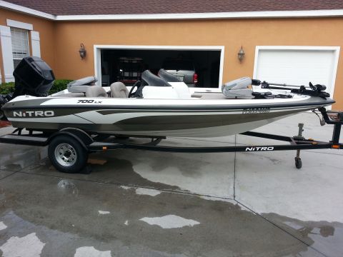 2003 Tracker Tournament - A Nitro 700 LX boat is parked on a trailer in front of a garage.