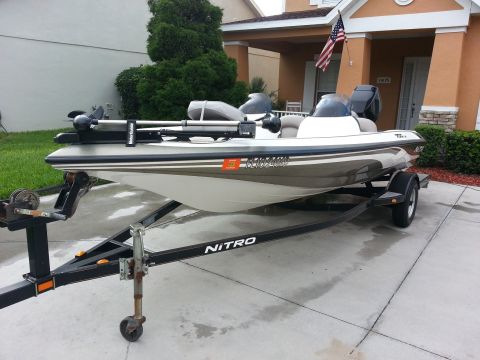 2003 Tracker Tournament - A Nitro boat is parked on a trailer in front of a house.