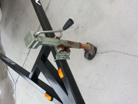 2003 Tracker Tournament - A boat trailer tongue with a rusty coupler and a small wheel is shown against a concrete surface.
