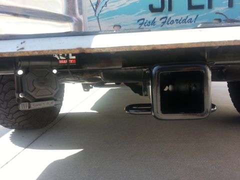 1994 Ford Bronco - Close-up view of a trailer hitch and its electrical connector, with a Florida-themed license plate visible.