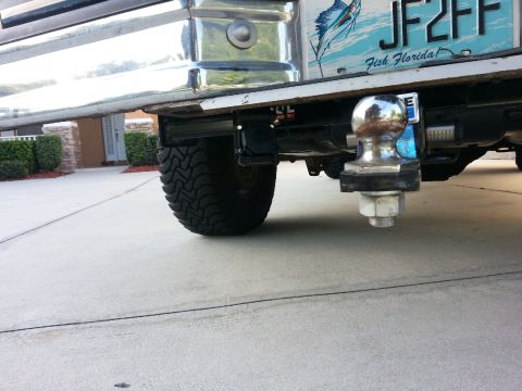 1994 Ford Bronco - The rear of a 1994 Ford Bronco is shown, focusing on the trailer hitch and tire.