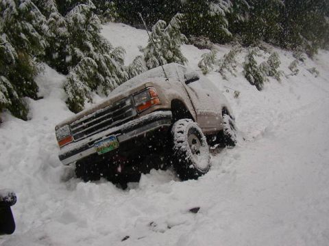 1994 Ford Explorer - A tan SUV is stuck in a snowy landscape, its front end partially obscured by snow.