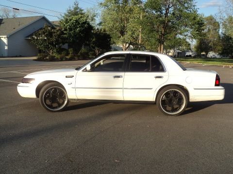 2000 Mercury Grand Marquis - Side profile of a white 2000 Mercury Grand Marquis sedan aftermarket black wheels.