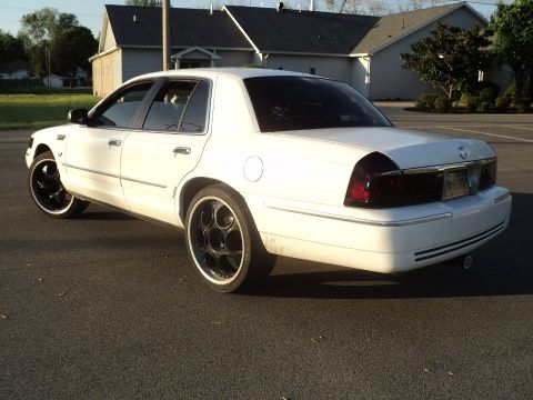 2000 Mercury Grand Marquis - White 2000 Mercury Grand Marquis with custom wheels seen from the rear quarter angle.