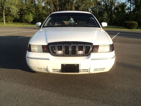 2000 Mercury Grand Marquis - Front view of a white 2000 Mercury Grand Marquis, a distinctive chrome grille and headlights.