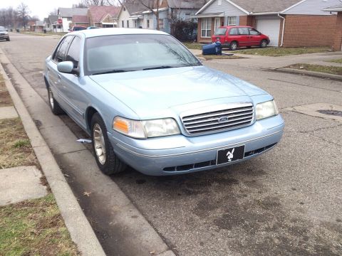 2000 Mercury Grand Marquis - This light blue sedan is parked curbside on a residential street.
