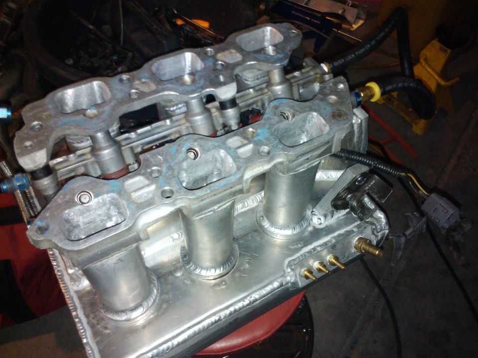 Aluminum intake manifold with welded runners and fuel injector ports