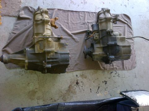 1994 Ford Bronco - Two transfer cases are shown side-by-side on a cloth covering a concrete floor.