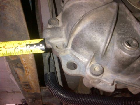 1994 Ford Bronco - A measuring tape is used to check a dimension on a vehicle's transmission housing.