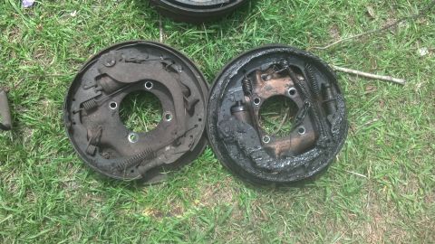 1983 Ford F-250 - Two used brake drums with brake shoes and springs are shown on the grass.