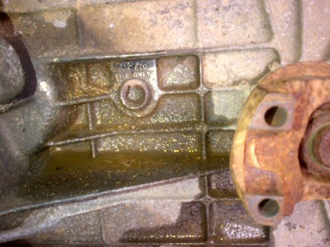 1994 Ford Bronco - Close-up of a transmission housing showing PTO and FRL ONLY markings, with some fluid present.