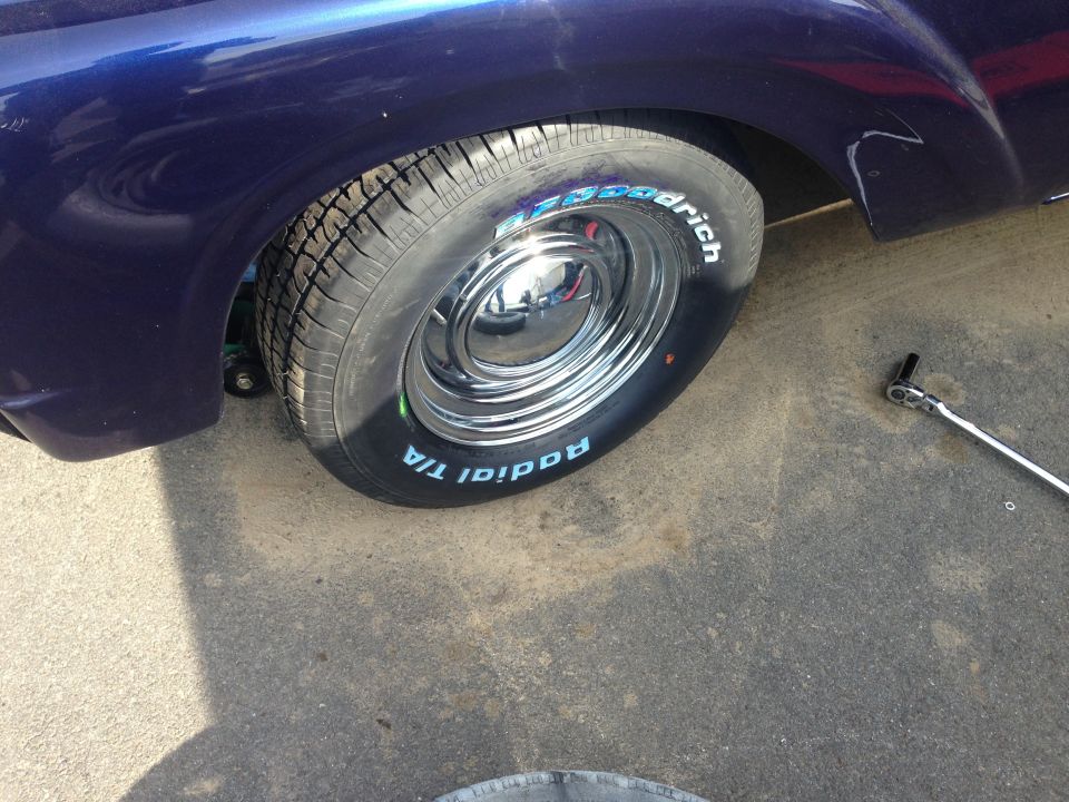 close-up of a shiny chrome wheel with BFGoodrich Radial T/A tires on a dark blue classic car