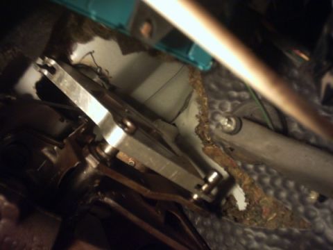 1991 Ford LTD Crown Victoria - This photo shows a close-up view of the clutch cable mechanism and associated linkages, likely from the interior of a vehicle.