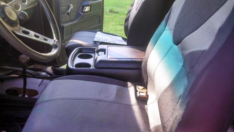 1979 Ford Bronco - The interior of a vehicle is shown, focusing on the driver's side and passenger seats, center console, and dashboard area.