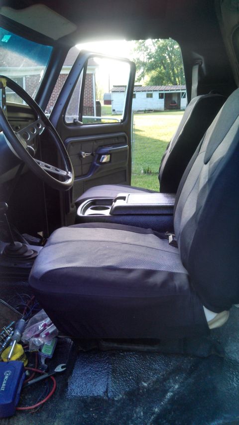 1979 Ford Bronco - The interior of a 1979 Ford Bronco, bucket seats and a view through the open door.