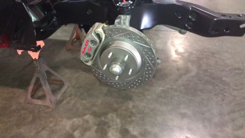 1972 Pontiac Trans Am - Close-up of a car's brake system, showing a drilled rotor and caliper, with the vehicle chassis visible above.